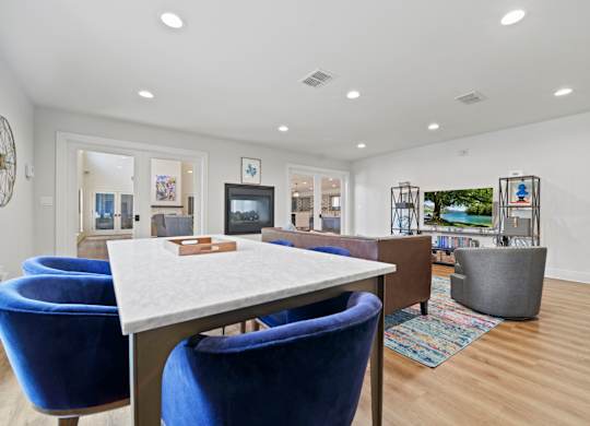a living room with a table and chairs and a television in the background