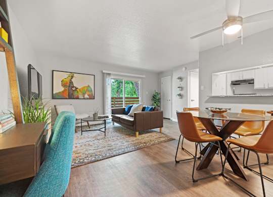 a living and dining room area with a table and chairs and a couch in the background