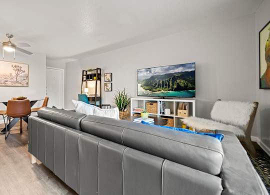 a living room and dining room with white walls and a ceiling fan