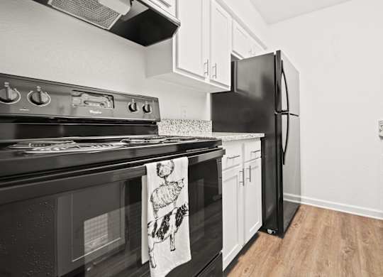 a kitchen with white cabinets and black appliances