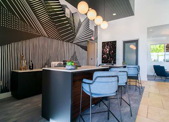 A modern office space with a black and white striped wall and a reception desk.