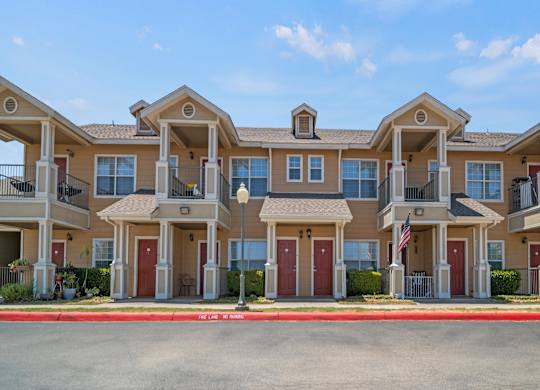 A row of townhouses with a clear blue sky above them.