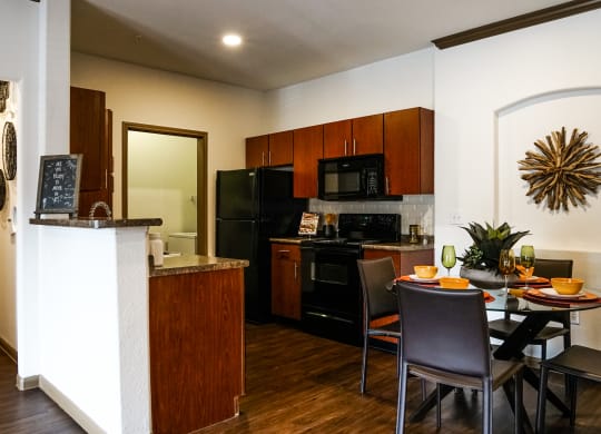 full kitchen with black appliances and a dining table with chairs