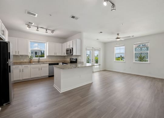 a kitchen and living room with hardwood floors and white walls