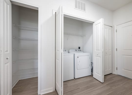 a bedroom with a washer and dryer and a closet with white doors