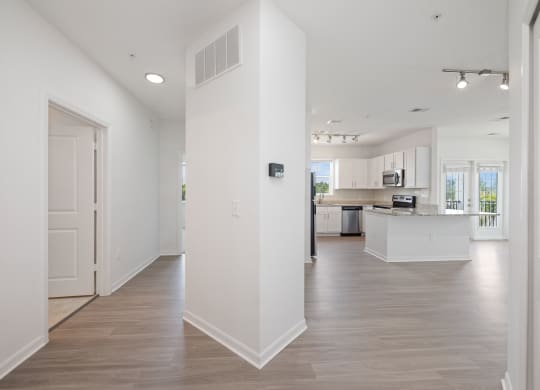 a bedroom with a medium sized bed and a kitchen with white cabinetry