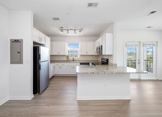 a kitchen with white cabinets and a large island with granite countertops
