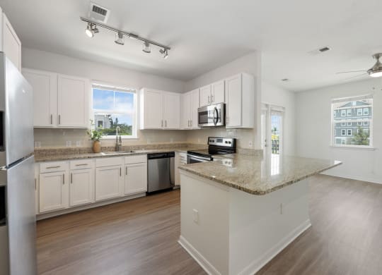 a kitchen with white cabinets and a granite counter top