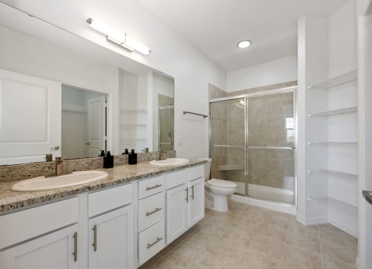 a bathroom with white cabinets and a granite countertop