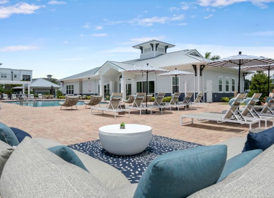 a pool with lounge chairs and umbrellas at the enclave at woodbridge apartments in sugar