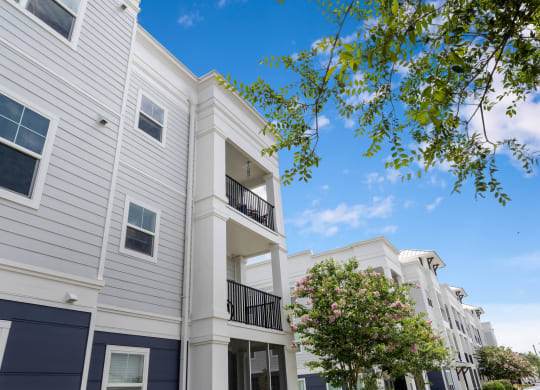 a picture of a white apartment building with a blue sky in the background