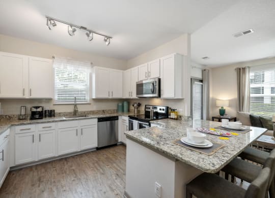 a kitchen with white cabinets and a granite counter top