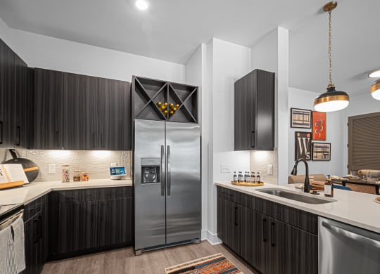 a kitchen with a stainless steel refrigerator and a sink