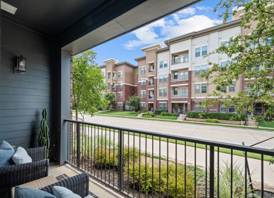 a balcony with a view of a street and some apartment buildings