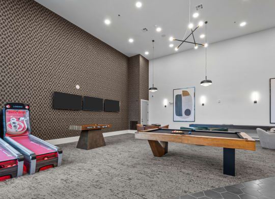 two pool tables in a room with televisions and other gaming equipment