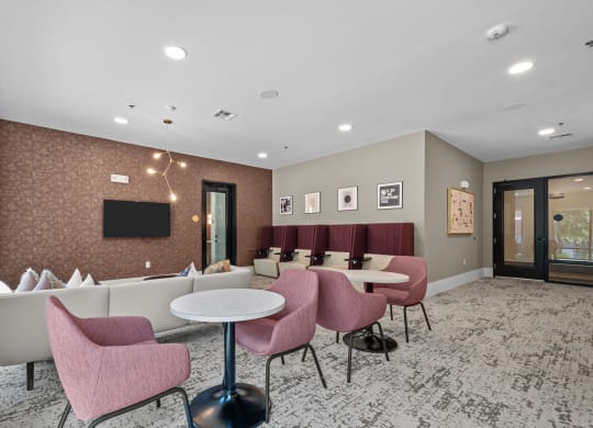 a lounge area with tables and chairs and a television