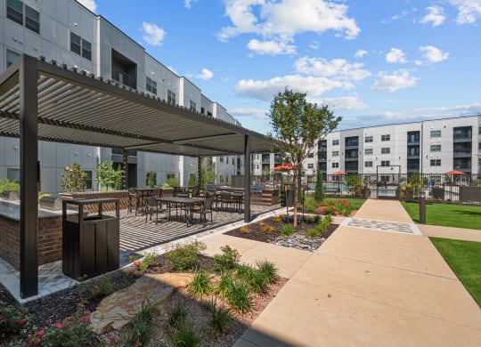 an outdoor patio with tables and chairs and a building in the background