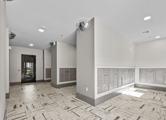 a large room with a wall of mailboxes and a door to a building