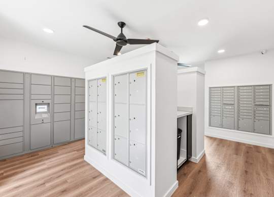A room with a ceiling fan and a cabinet with drawers.