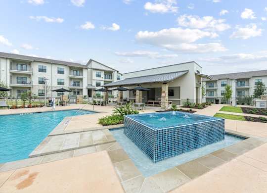 A swimming pool in front of apartment buildings.