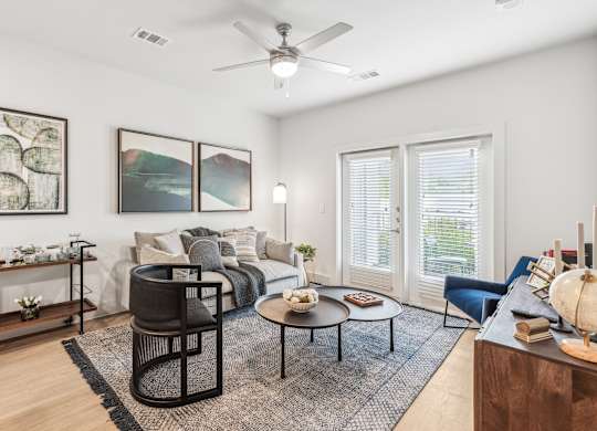 A living room with a black chair, a coffee table, and a painting on the wall.