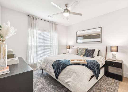 A bedroom with a large bed and a ceiling fan.