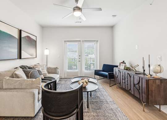 A living room with a couch, chair, and a table with a vase on it.