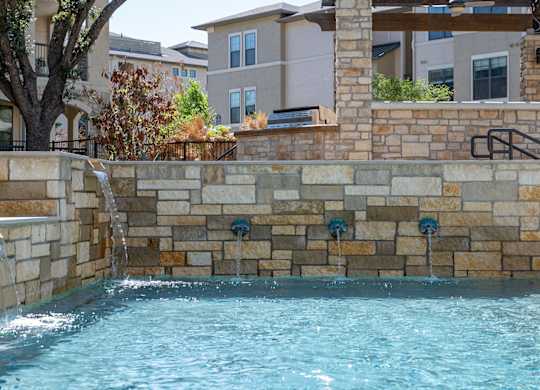 A pool with a waterfall feature in the middle of it.