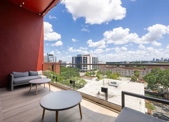 a view of the city from a balcony with couches and tables