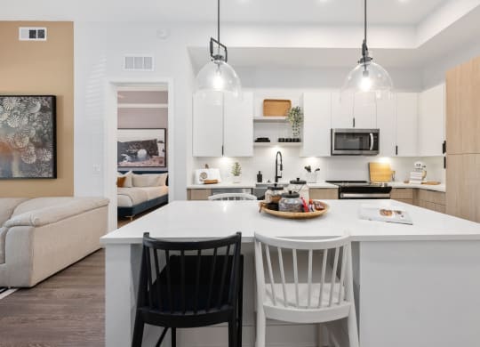 an open kitchen with a large island with two chairs