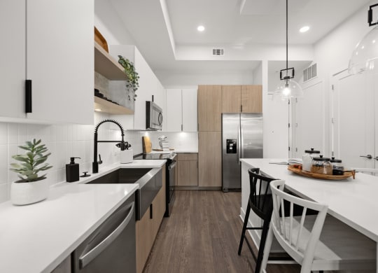 a modern kitchen with white counter tops and a large island with stools