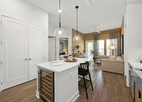 a kitchen and living room with white cabinets and a white counter top