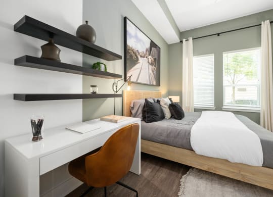 a bedroom with a large bed and a desk with a chair