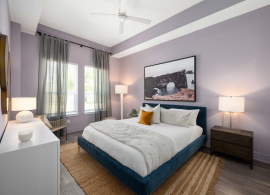 a bedroom with purple walls and a white bed