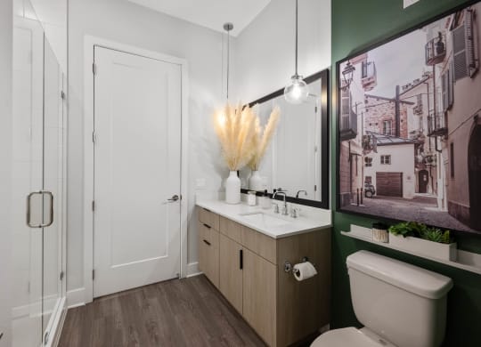 a bathroom with a toilet sink and mirror and a shower