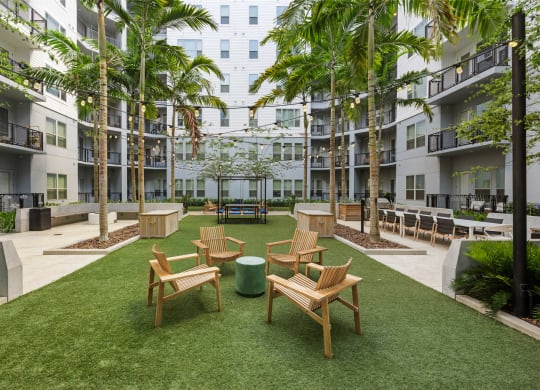 an open courtyard with tables and chairs in an apartment building