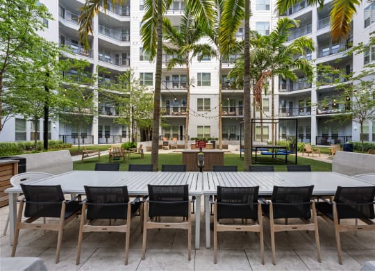 a large table and chairs in a courtyard at an apartment building