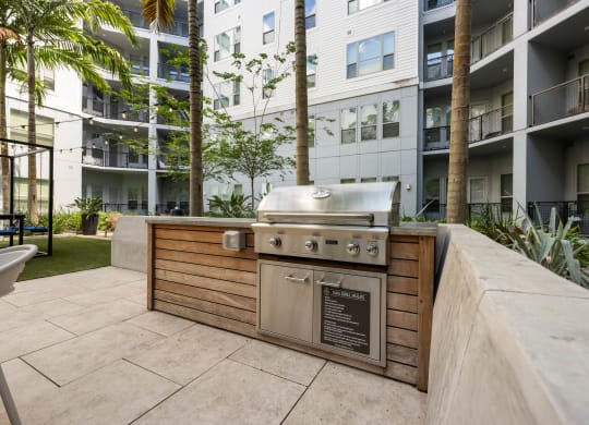 a barbecue grill on a patio in front of an apartment building