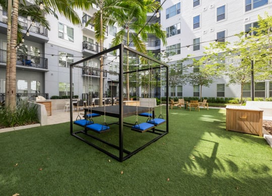 a playground with blue lounge chairs in a courtyard