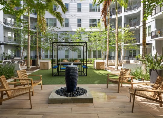 a courtyard with tables and chairs and a water fountain