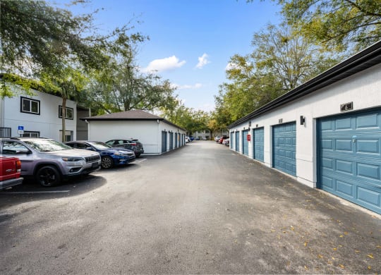 a city street with garages and parked cars