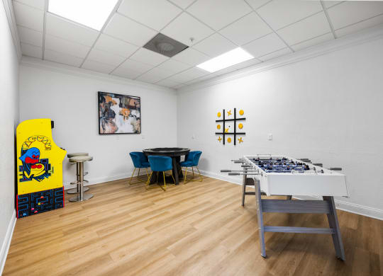 a room with a table with a giant chessboard and a game table and chairs