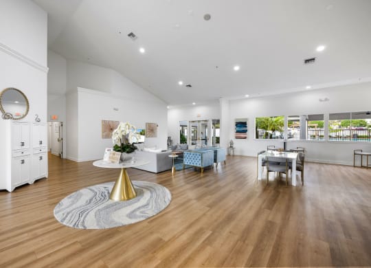 a living room with white walls and wooden floors and a table with a mirror