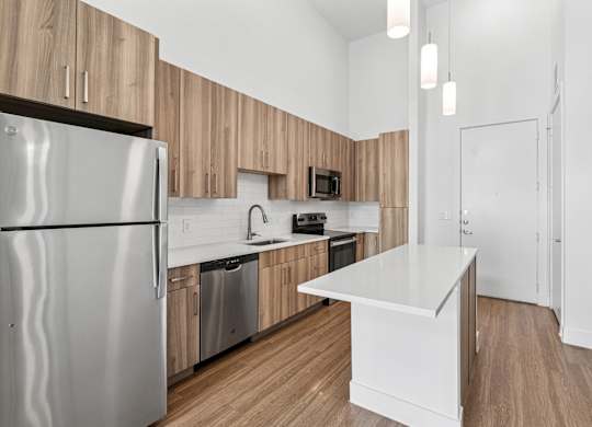 A modern kitchen with wooden cabinets and a white island.