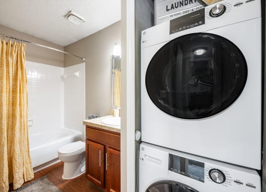 a washer and dryer in a bathroom next to a toilet and a sink