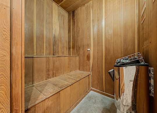a wood paneled bathroom with a shower and a sink