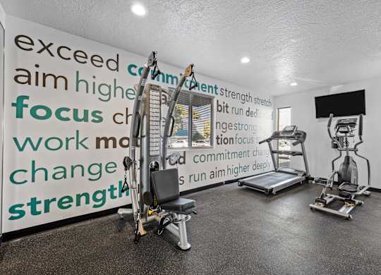 a gym with weights and a wall with words on it