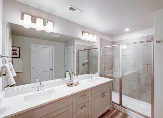 A bathroom with a white sink and a large mirror.