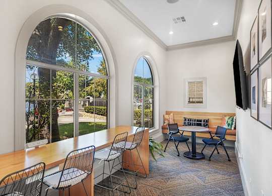 A room with a table and chairs and a television.