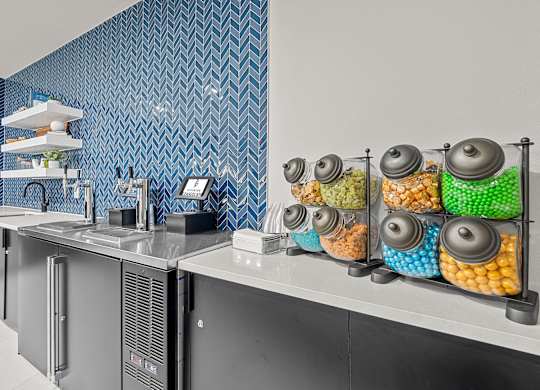 A kitchen with a blue tiled wall and a white counter.